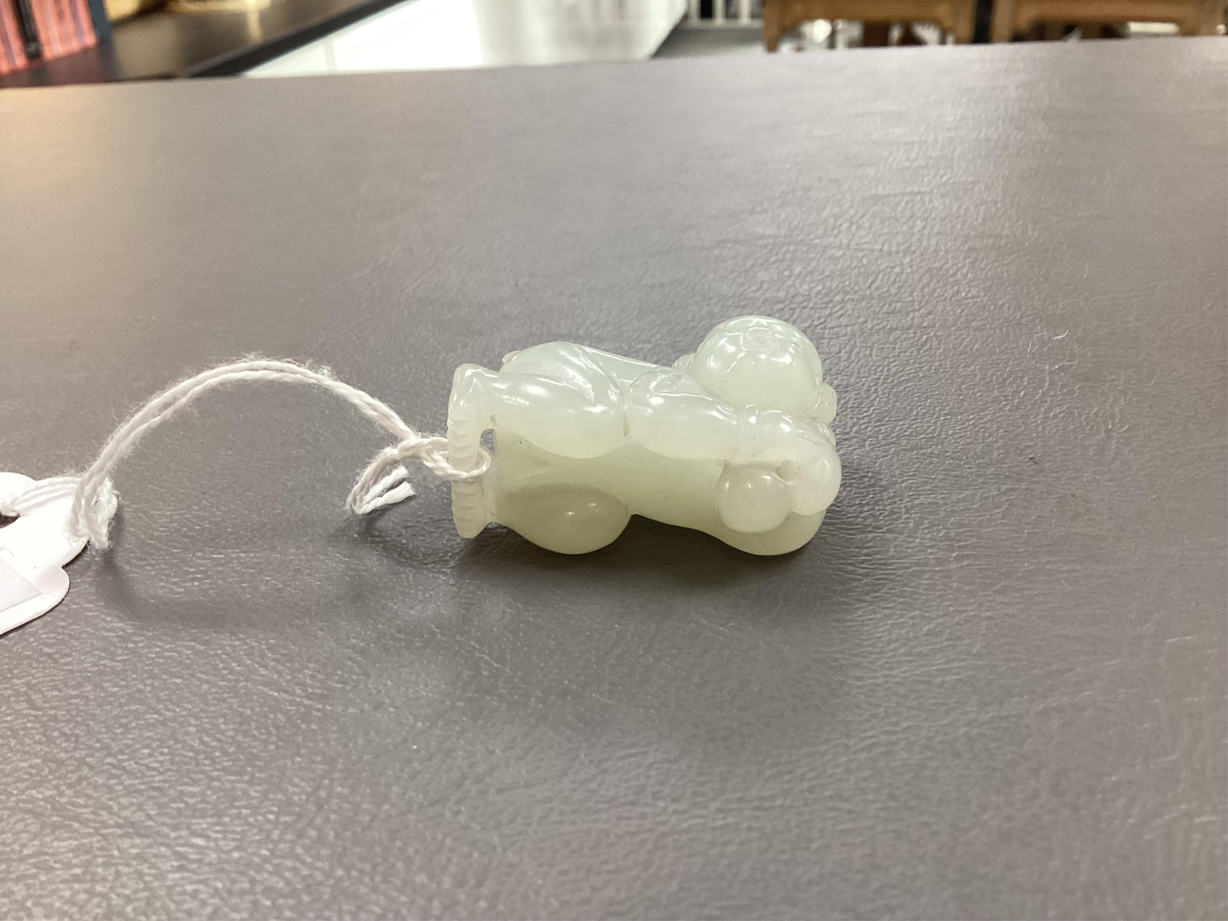 A Chinese white jade figure of a crouching boy, 19th/20th century